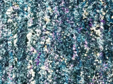 Colorful textured carpet with a mix of blue, purple, and white accents.