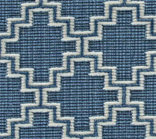 Blue geometric patterned carpet with textured surface and intricate design.