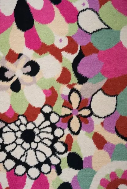 Vibrant floral patterned rug with colorful blossoms and bold black outlines, ideal for modern home décor.