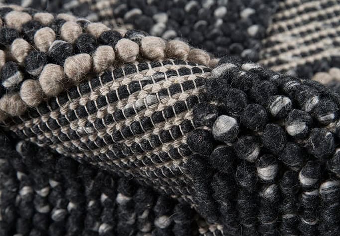 Vivid patterned area rug with black, beige, and gray geometric design, perfect for modern home decor.