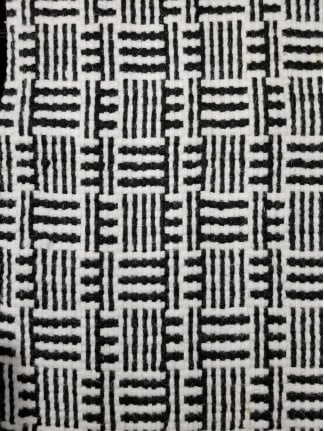 Intricate black and white woven carpet pattern for stylish flooring options.