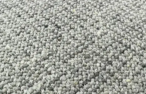 Plush light gray carpet with textured fibers, ideal for residential or commercial flooring.
