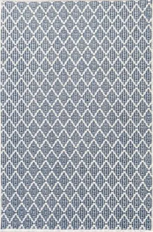 Diamond-patterned blue and white area rug for modern interior flooring.