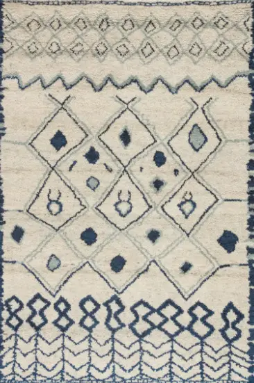 Handwoven Moroccan-inspired rug with geometric patterns in blue and white.