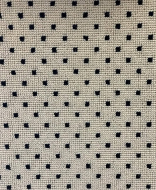 Polished beige and black perforated leather upholstery fabric for furniture and interiors.