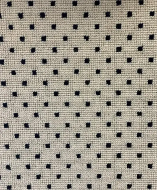 Polished beige and black perforated leather upholstery fabric for furniture and interiors.