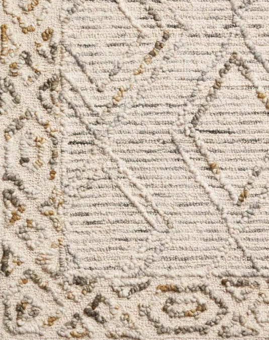 Cream textured area rug with geometric patterns for modern interior decor.