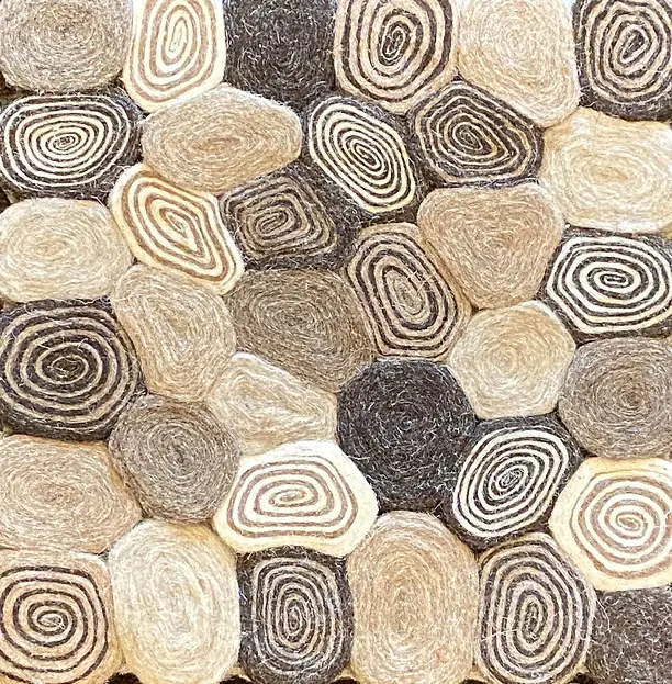 Nature-inspired stone mosaic floor with spiral patterns and neutral tones.