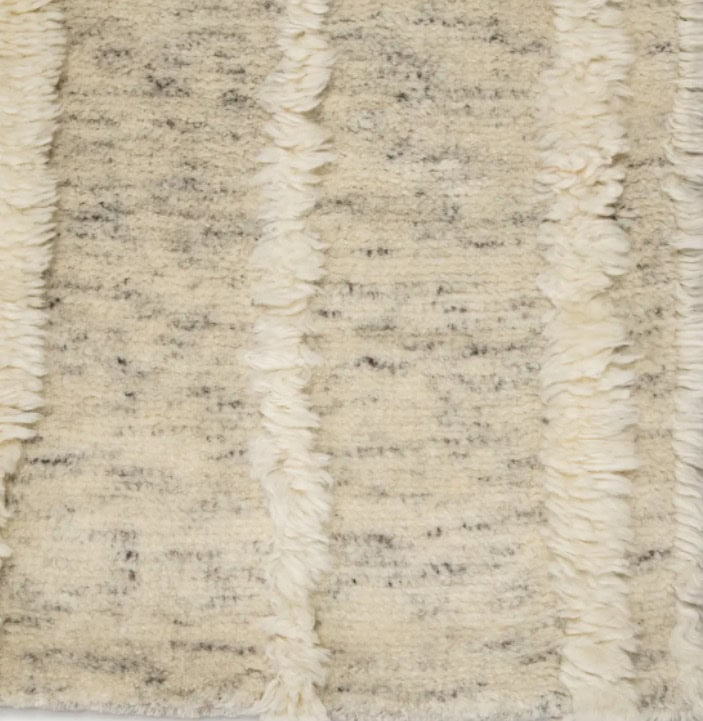 Soft cream and beige shag rug with textured stripes, ideal for modern or cozy home flooring.