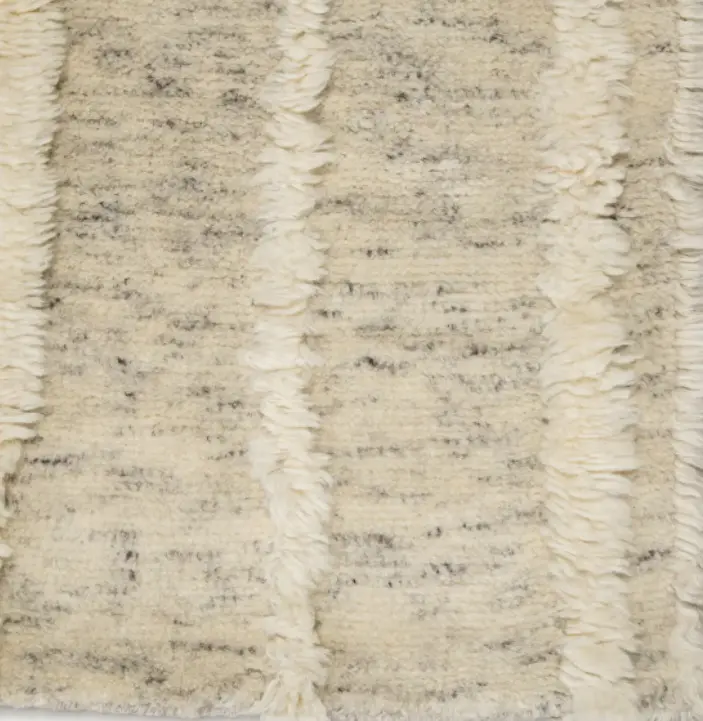 Soft cream and beige shag rug with textured stripes, ideal for modern or cozy home flooring.