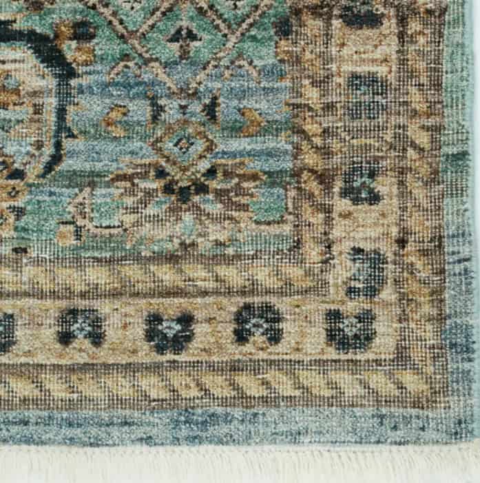 Vintage ornate area rug with intricate geometric pattern and distressed finish.