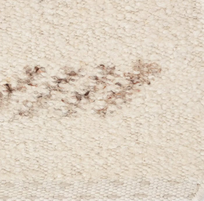 Frayed area on plush beige carpet with slight stain or damage.