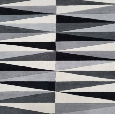Colorful geometric patterned flooring with bold black, white, and gray shapes.