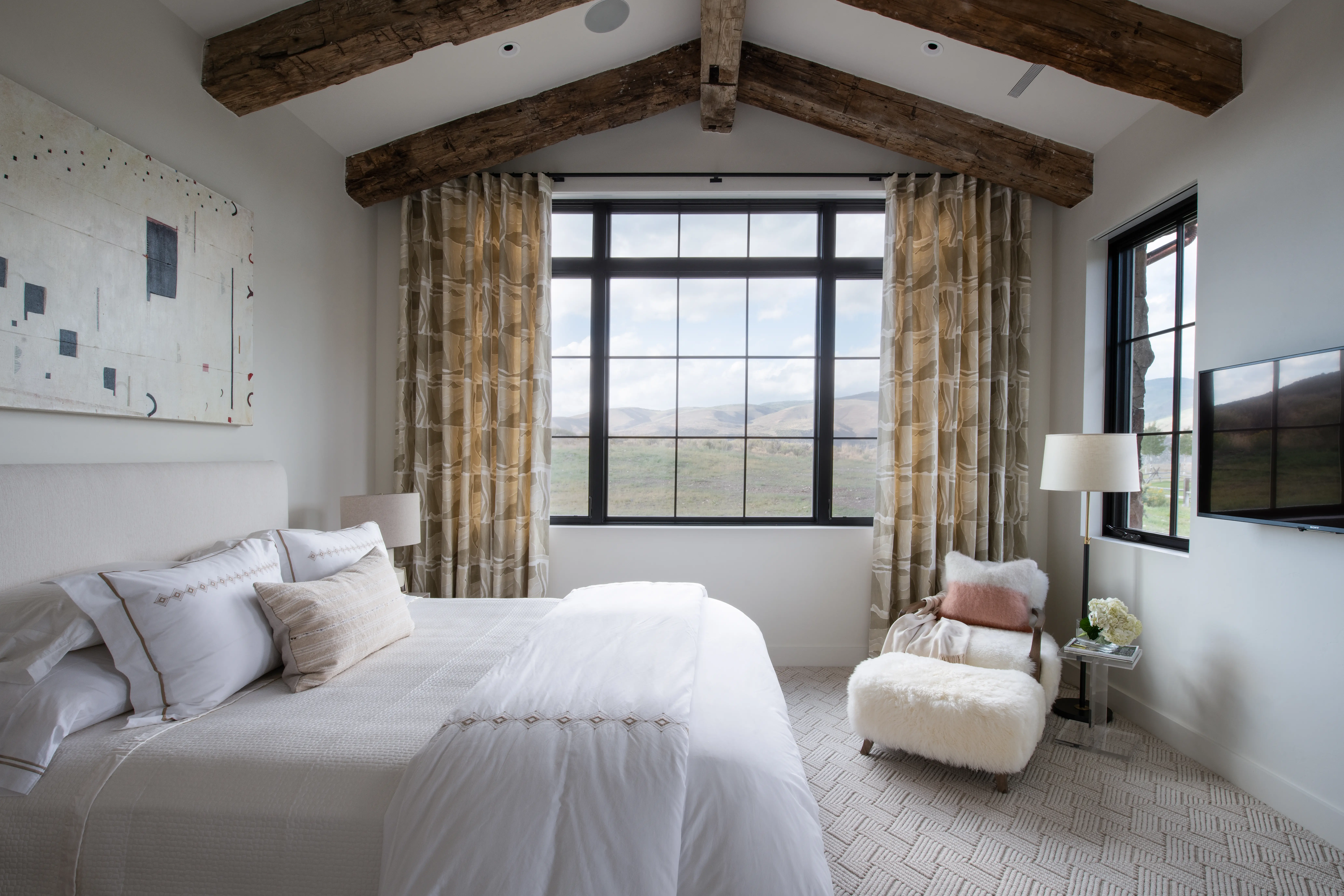 Luxurious bedroom with modern rustic flooring and scenic mountain view, perfect for home remodeling.