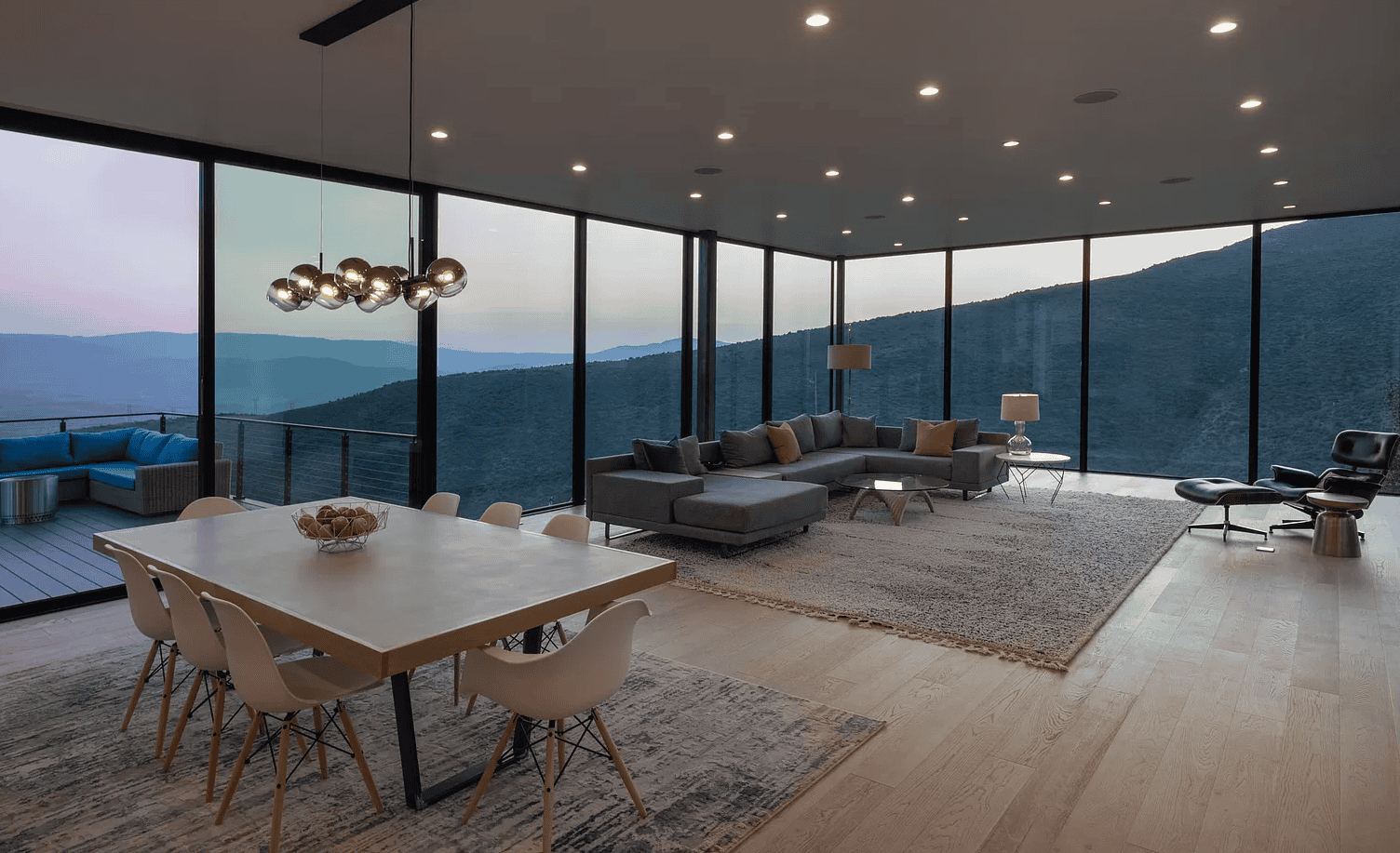 Contemporary living room with large floor-to-ceiling windows featuring elegant hardwood flooring and modern decor.