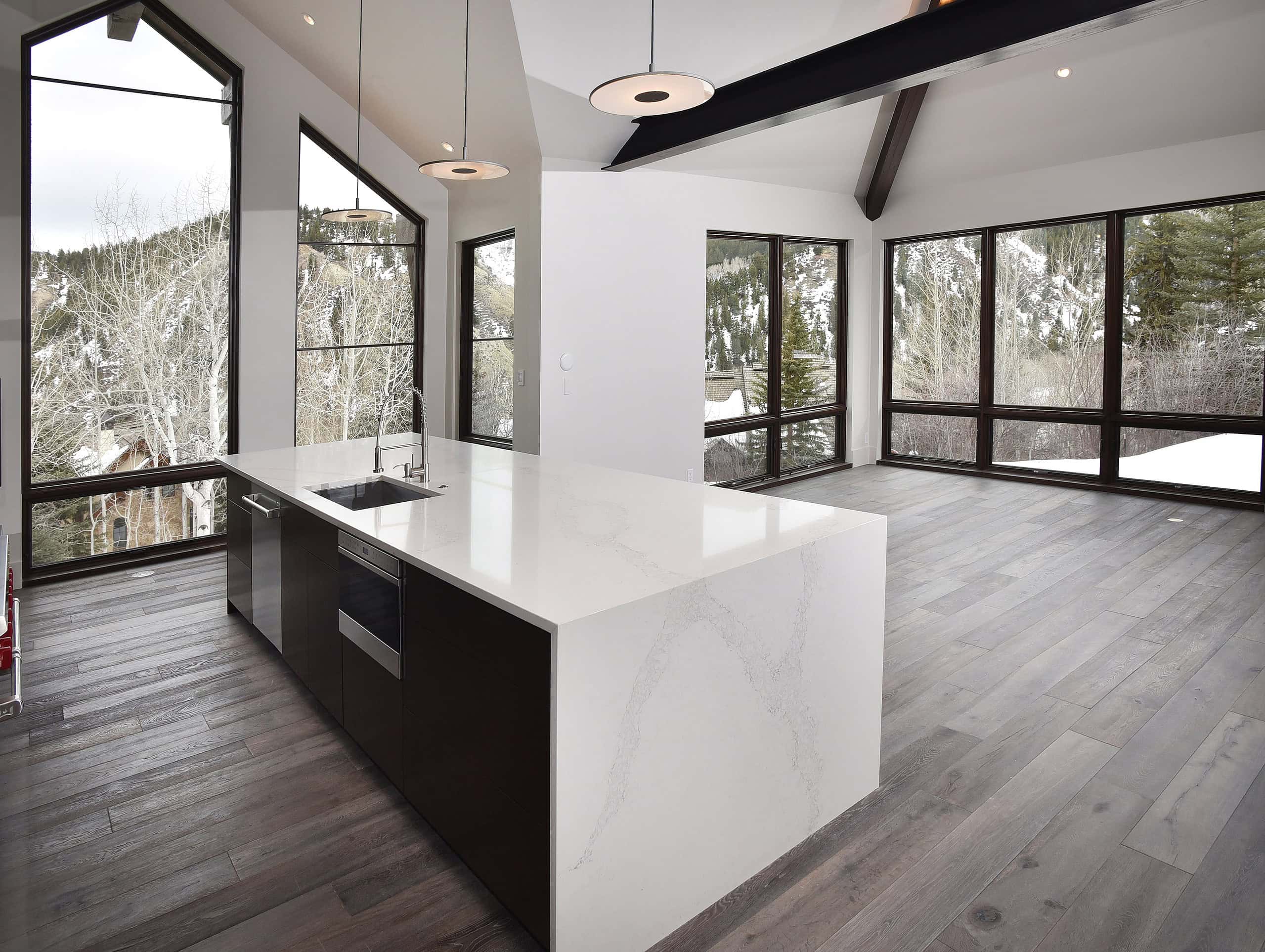 Sleek modern flooring with large windows in a contemporary home kitchen.