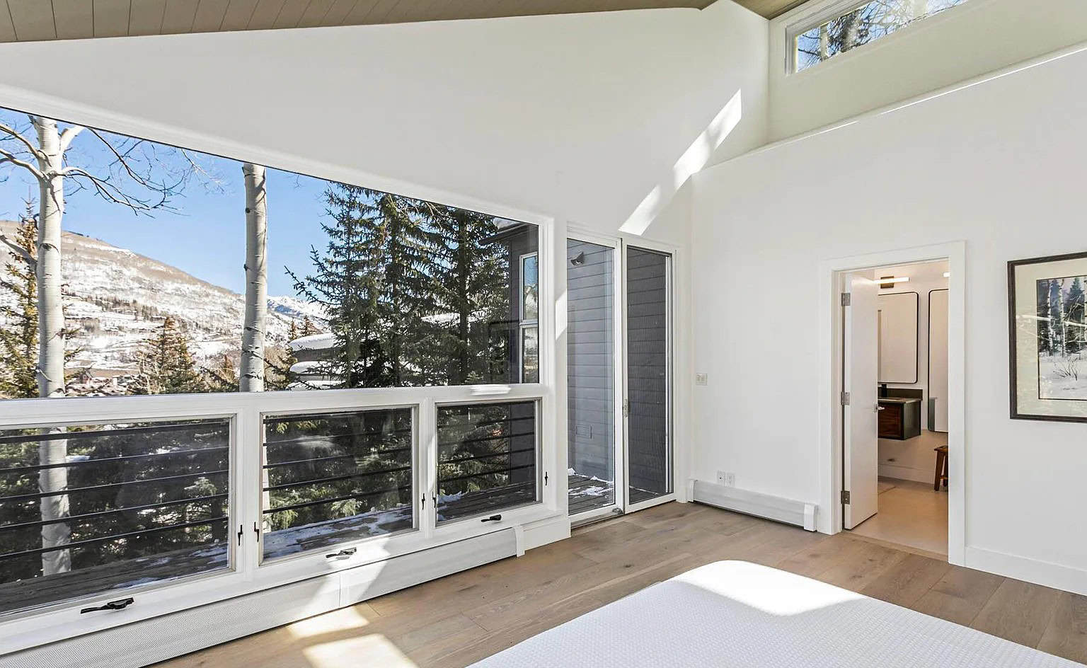 Bright mountain view living room with large windows and natural light, modern home interior design.