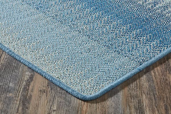 Blue textured area rug on hardwood floor, ideal for living rooms and offices, durable and stylish flooring solution.