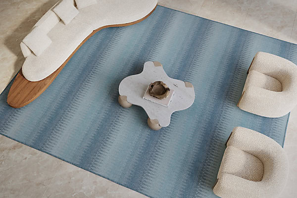 Soft blue area rug with modern beige seating and minimalist coffee table for stylish home flooring.