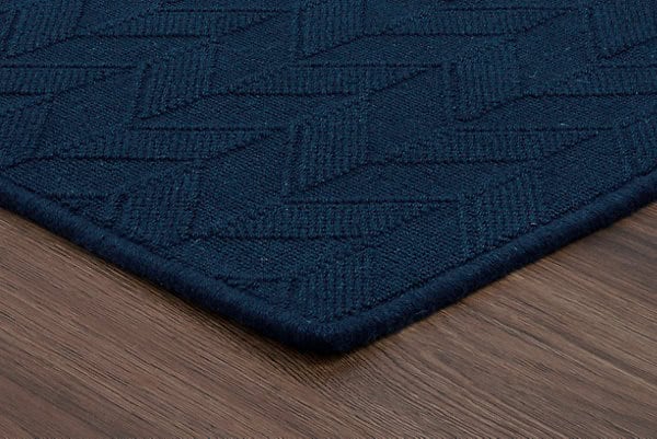 Luxurious navy blue textured carpet with geometric pattern and plush finish for residential or commercial spaces.