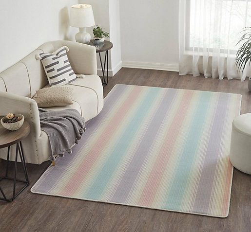 Soft pastel striped area rug in modern living room with white sofa and cozy decor.