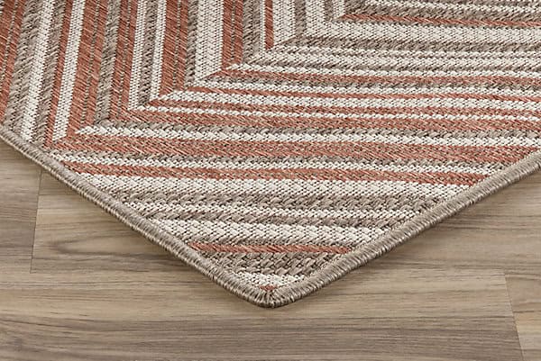 Vibrant geometric patterned area rug over hardwood flooring in a modern living space.