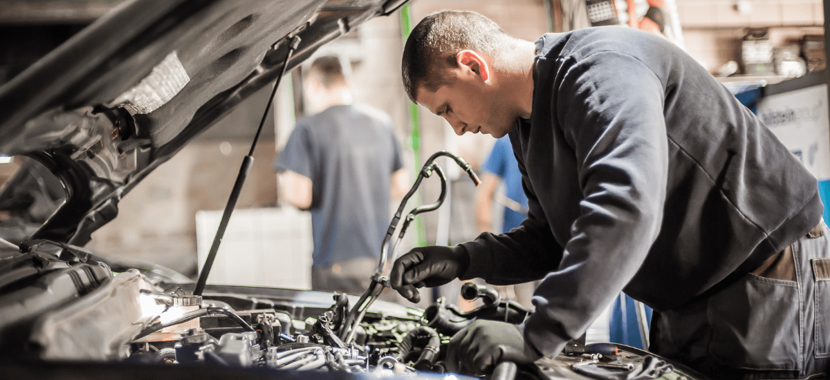 Skilled mechanic inspecting vehicle engine at Delta Fleet Services LLC.