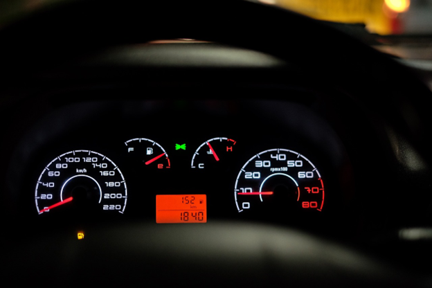 Car dashboard showing oil change warning light and gauges.