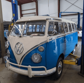 Classic blue and white Volkswagen Type 2 vintage van in a workshop.
