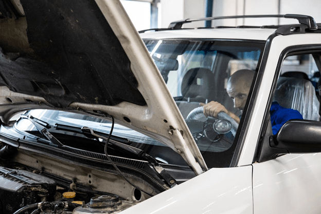Technician inspecting engine during rebuild at Dettwiler Brothers Repair.