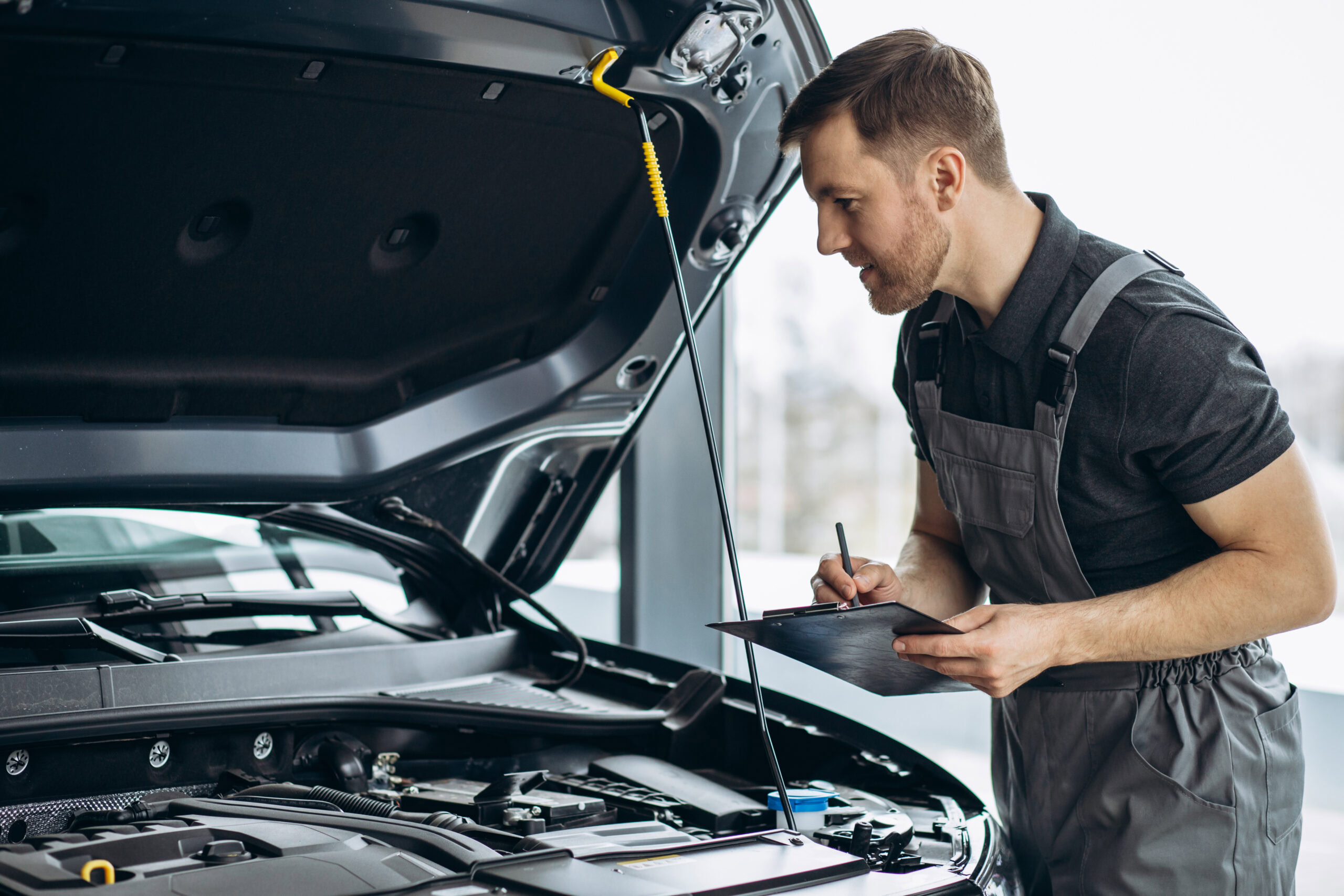 Auto mechanic inspecting engine for preventive maintenance in Shippensburg.