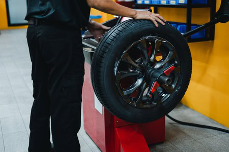 Professional wheel alignment being performed on a vehicle at Dettwiler Brothers Repair.