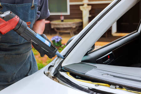 Auto mechanic performing engine repair on a car at Dettwiler Brothers Repair.
