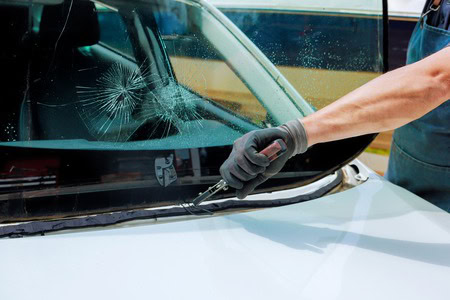 Auto glass repair technician fixing a cracked windshield.