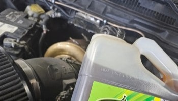 Close-up of engine oil container in a car engine bay.