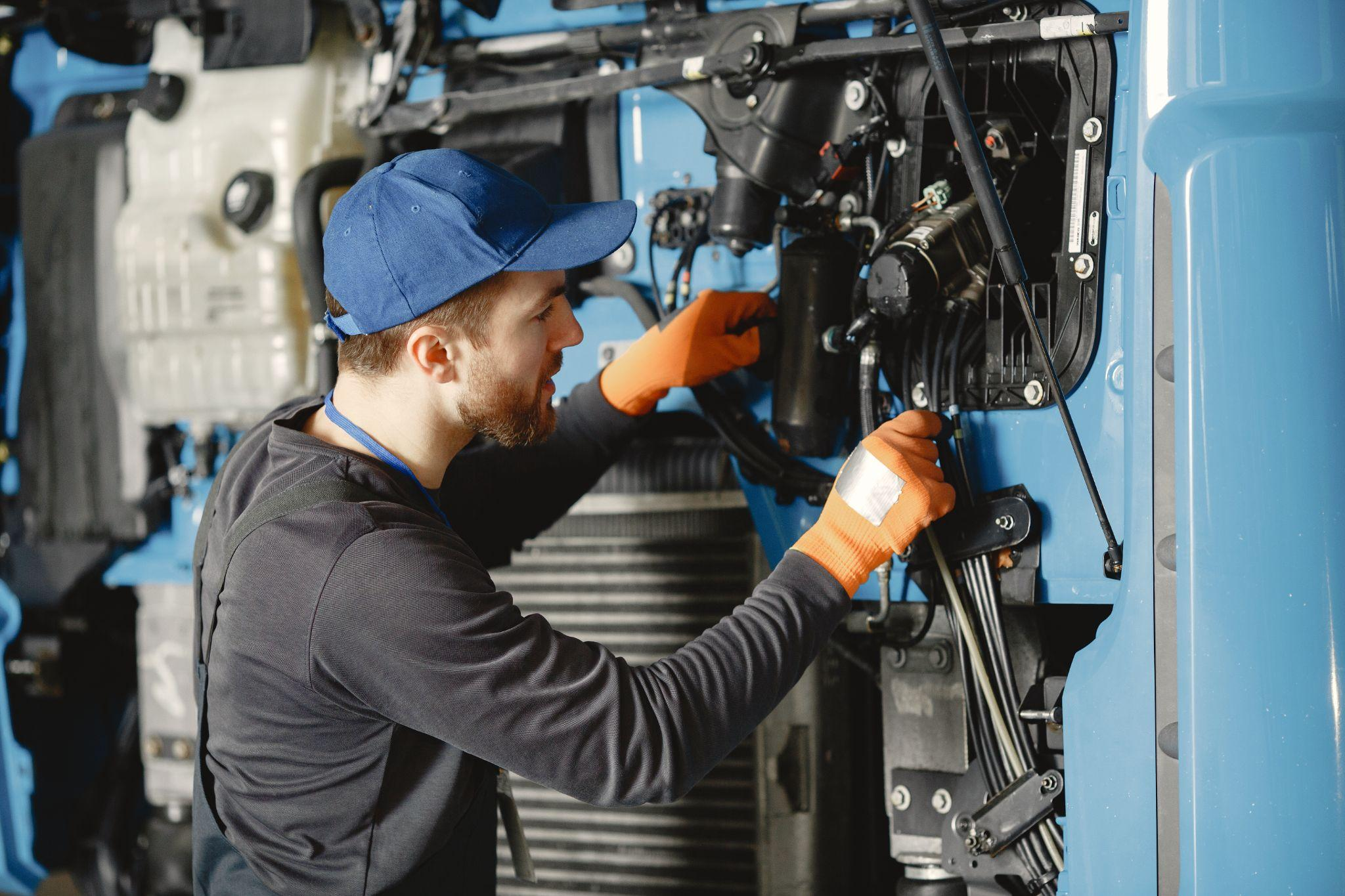Mechanic conducting engine repairs on a diesel truck