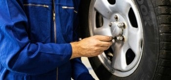 Technician changing a car tire at Higgins Driscoll’s Automotive.