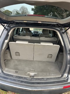 Auto care clinic trunk space with beige interior and rear seats folded down.