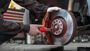 Brake rotor being inspected and replaced by professional technicians.