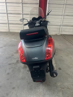 Black scooter parked inside DrivenMotos Auto Care Clinic.