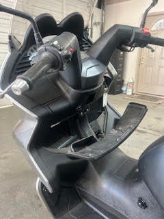 Close-up of electric scooter handlebar and dashboard at DrivenMotos.