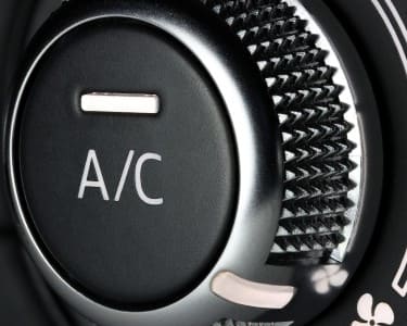 Close-up of car air conditioning control knob with textured grip.