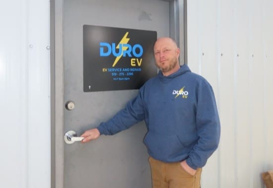 Duro EV technician standing by electric vehicle service door.