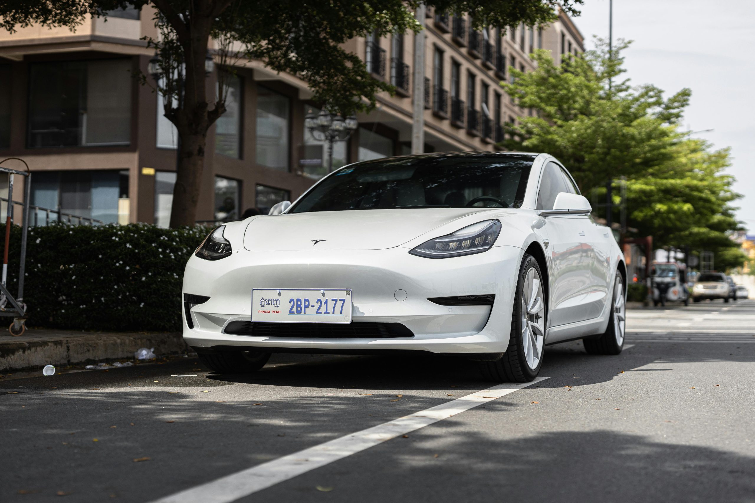 Electric Tesla Model 3 parked on urban street highlighting EV battery technology.