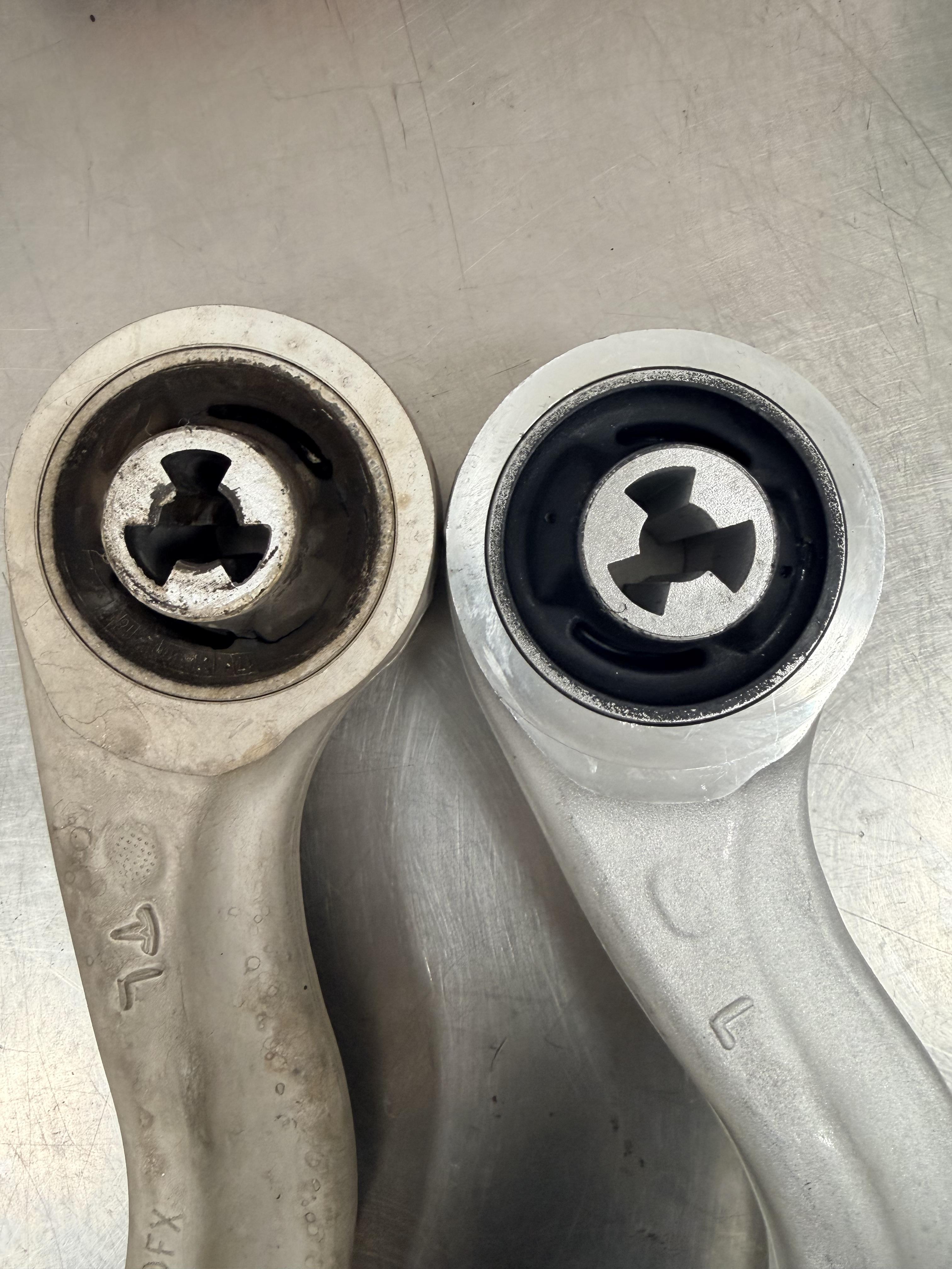 Comparison of worn and new control arm bushings for Tesla vehicles.