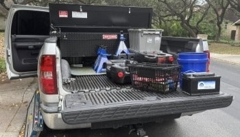 Tools and equipment for vehicle repair and maintenance in truck bed.
