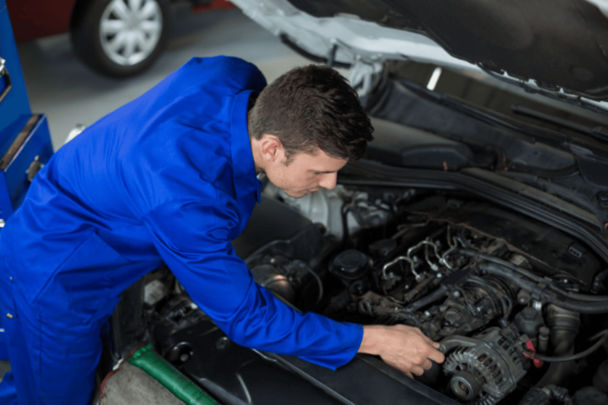 Auto mechanic inspecting engine during winter maintenance in San Antonio.