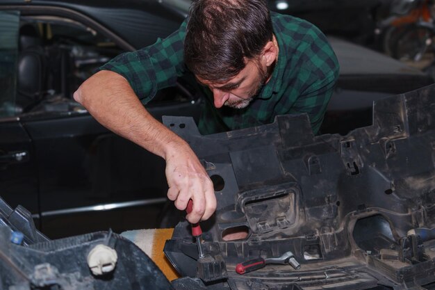 Auto mechanic diagnosing car engine issues on-site.
