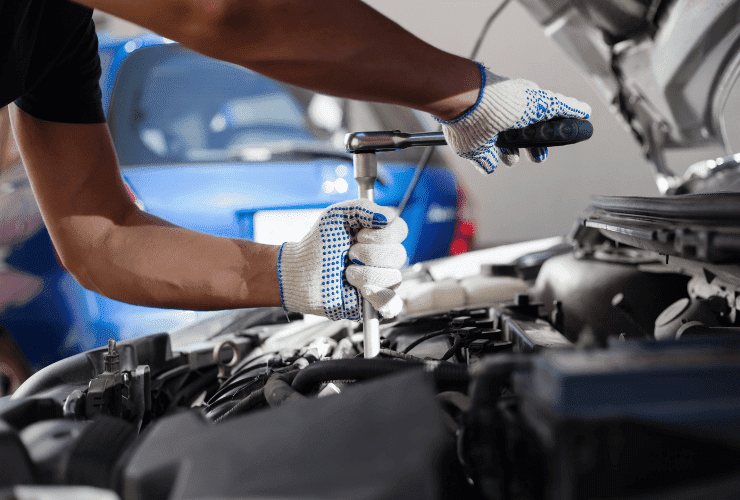 Auto repair technician inspecting car engine with tools in San Francisco.