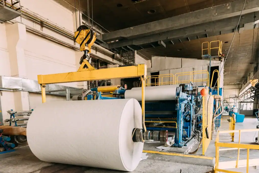 Industrial paper roll production equipment in a factory setting.
